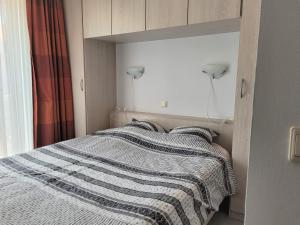 ein Schlafzimmer mit einem Bett mit einer gestreiften Decke in der Unterkunft Gauguin in Nieuwpoort