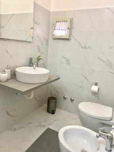 a white bathroom with a sink and a toilet at Casa Tortora in Santa Maria di Castellabate