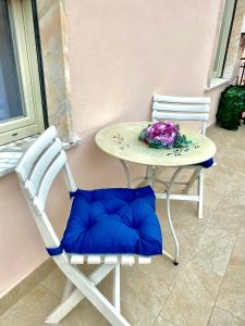 a table with two chairs and a blue pillow on it at Casa Tortora in Santa Maria di Castellabate