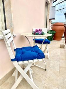 a white chair and a table and a table and chairs at Casa Tortora in Santa Maria di Castellabate
