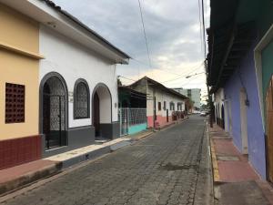 uma rua vazia numa cidade com edifícios coloridos em El Callejon Guest House em León