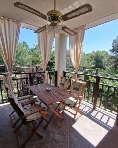 einen Tisch und Stühle auf einem Balkon mit Deckenventilator in der Unterkunft Quiet apartment with big terrace in Santa Marina with parking in Sozopol