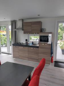 een keuken met houten kasten, een wastafel en een tafel bij Chalet Moderna Putten in Putten