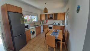 een keuken met een tafel en een koelkast bij Villa Selene in Archangelos