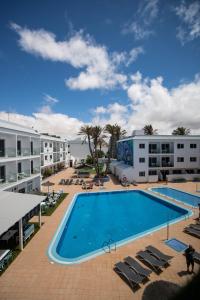 an image of a swimming pool at a resort at Corralejo Surfing Colors Hotel&Apartments in Corralejo