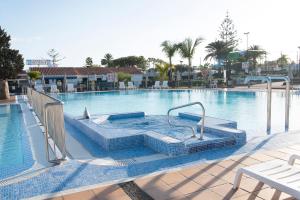 a large swimming pool with a hot tub in it at Bungalow Atos With Private Garden in Playa del Ingles