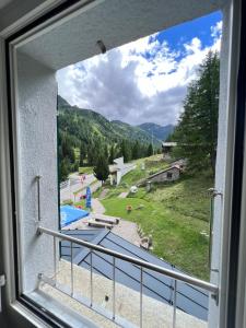 a window with a view of a pool and mountains at Ristorante Albergo All'acqua in Bedretto +11 photos