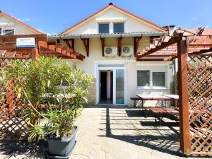 a house with a table and a wooden fence at Pelso Apartman in Zamárdi