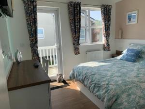 Schlafzimmer mit einem Bett, einem Schreibtisch und einem Fenster in der Unterkunft Chalet 283 in Bridlington