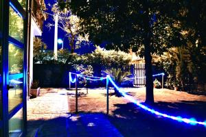 BuenRetiroPe - confortevoli bilocali con giardino في بيسكارا: مجموعة من الأضواء الزرقاء في الفناء في الليل