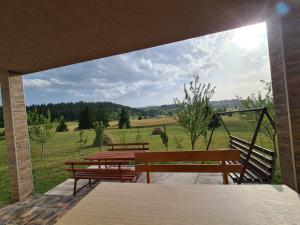 a patio with benches and a view of a field at Vila Coka in Nova Varoš