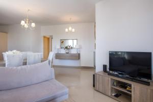 uma sala de estar com um sofá e uma televisão de ecrã plano em Casa Magnolia - Spacious Home in heart of Akrotiri em Chania Town