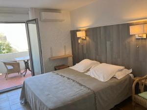 a bedroom with a large bed and a balcony at Hotel Costa Verde in Moriani Plage