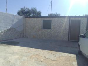 a house with a stone wall and a car parked in front at DON BOSCO 2 in Bari Palese