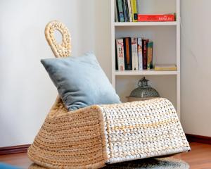 uma cadeira de vime com uma almofada num quarto em Apartments Muntidor em Rab