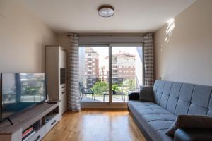 a living room with a blue couch and a television at Apartamento Bulevar 2 in Castellón de la Plana