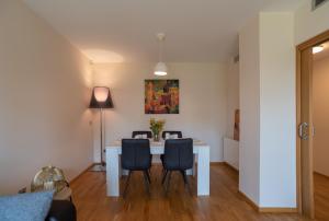 Un comedor con una mesa y sillas blancas. en Apartamento Bulevar 2 con parking gratuito, en Castellón de la Plana
