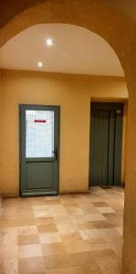 una stanza vuota con due porte verdi e un pavimento piastrellato di Loft 80m2 en plein cœur de la vieille ville 3 étoiles a Tolone