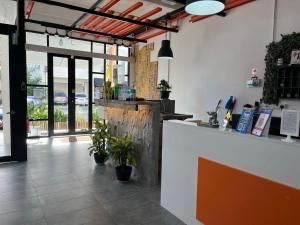 a restaurant with a counter with potted plants at Knight Alley Hotel in Taiping