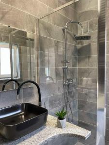 a bathroom with a black sink and a shower at Apartmani Andrić - Stylish & Peaceful Apartment with Free Parking - 10 min Walk to Old Town in Trebinje +56 photos