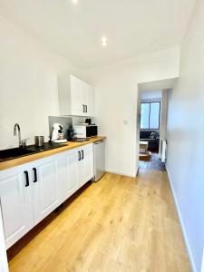 een keuken met witte kasten en een houten vloer bij Moulins: Superbe appartement centre ville in Moulins