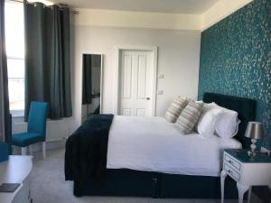 um quarto com uma cama e uma parede azul em Loggans Lodge em Hayle
