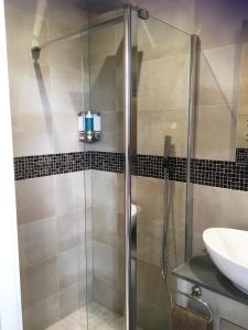 a shower with a glass door next to a sink at Loggans Lodge in Hayle