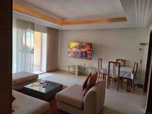 uma sala de estar com um sofá e uma mesa em Paradis Plage Pieds dans l'eau - Superbe Appartement em Agadir