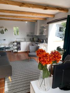 una sala de estar con un jarrón con flores naranjas sobre una mesa en Villa Laguneta en Gaucín