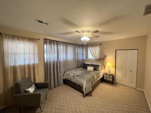um quarto com uma cama e uma cadeira e uma ventoinha de tecto em Whispering Oak Mansion em Bear