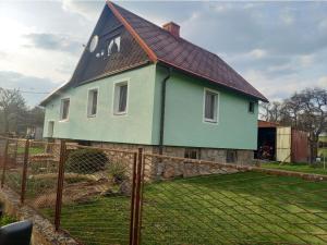 una casa con techo de gambrel y una valla en Apartmán U jelena en Zvole