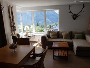 sala de estar con sofá y mesa en Las mejores vistas del valle. Apartmento 65m.WIFI, en Cerler