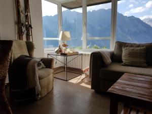 sala de estar con sofá y ventana grande en Las mejores vistas del valle. Apartmento 65m.WIFI, en Cerler