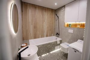 La salle de bains est pourvue d'une baignoire, de toilettes et d'un lavabo. dans l'établissement Нова гарна та чиста, квартира біля парку та озера, à Ternopil