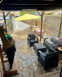 a patio with chairs and a table and an umbrella at Maison Lolly corse wifii free in Borgo