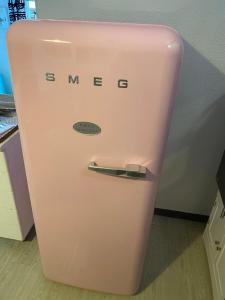 a pink refrigerator with the words smug on it at Maison Lolly corse wifii free in Borgo