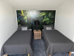 2 camas individuales en una habitación con un mural en Loft Wohnung Appartement auf 2 Etagen, Nähe Neckar, en Neckarwestheim