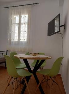 een eetkamer met een tafel en groene stoelen bij Zoe's house in Argostoli in Argostoli