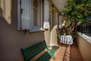un banco verde sentado al lado de un edificio en Zoe's house in Argostoli, en Argostoli