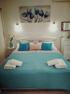 een slaapkamer met een groot bed met blauwe kussens bij Lucija in Primošten