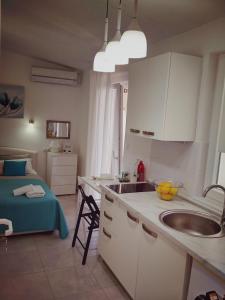 een keuken met een wastafel en een bed in een kamer bij Lucija in Primošten