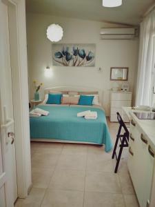 een slaapkamer met een bed met een blauwe sprei bij Lucija in Primošten