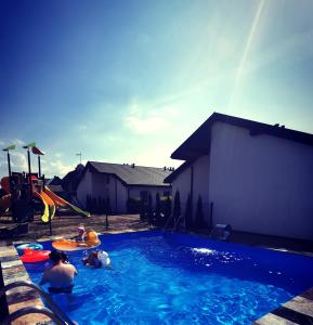 un grupo de personas jugando en una piscina en Domki i Pokoje Baltimor, en Grzybowo