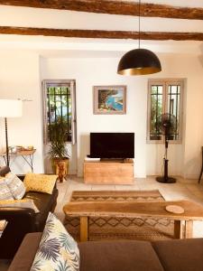 sala de estar con sofá y TV de pantalla plana en Sous le Clocher en Marsella