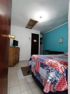 1 dormitorio con cama y pared azul en Hostal Caleta Abarca, en Viña del Mar