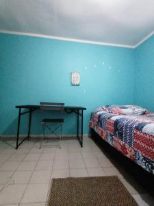 1 dormitorio con cama y escritorio en la pared en Hostal Caleta Abarca, en Viña del Mar