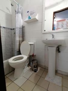 a bathroom with a toilet and a sink at Hostal Caleta Abarca in Viña del Mar