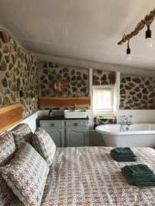 1 dormitorio con cama, bañera y lavamanos en La Maison du Potager, en Saint-Racho
