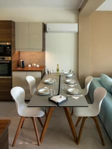 une salle à manger avec une table et des chaises blanches dans l'établissement ELEGANT BEACH HOUSE, à Artemi