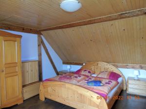 a bed in a room with a wooden ceiling at Gdzie diabeł mówi dobranoc in Pisz